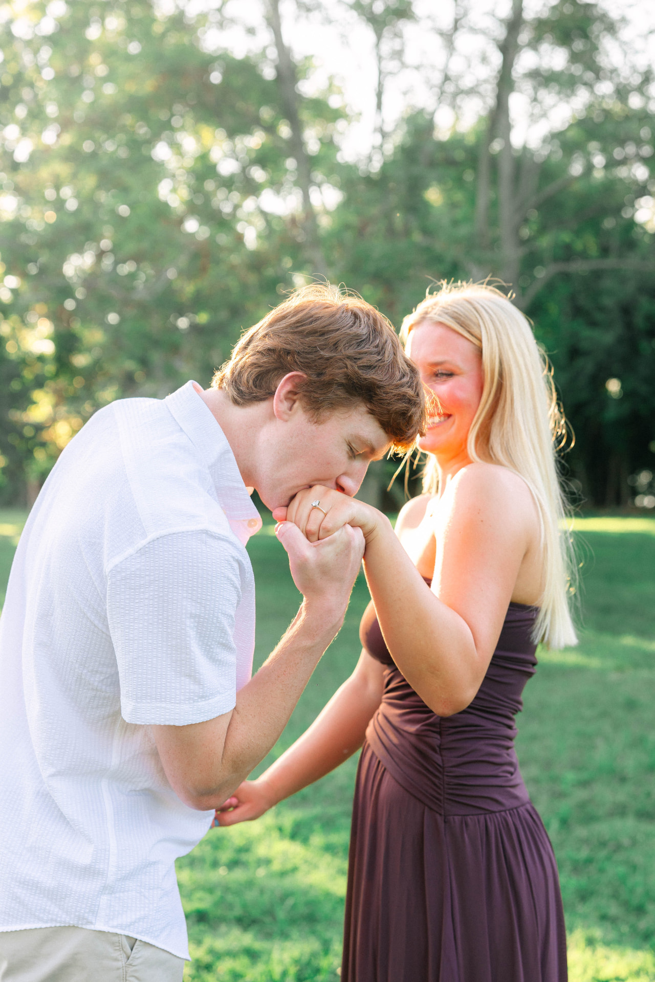 Colin kissing Samantha's hand as she smiles in the park